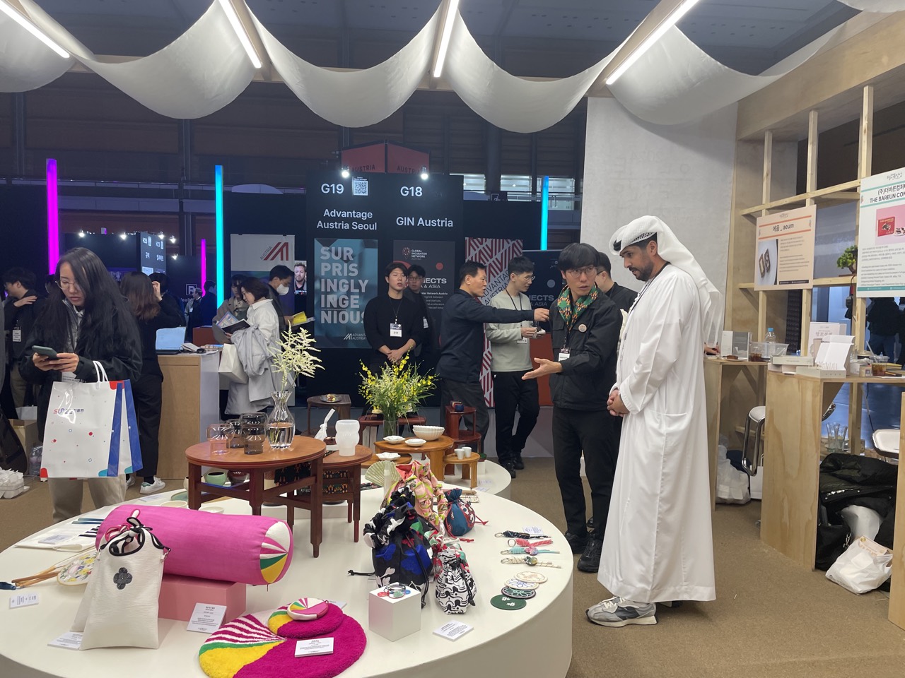 The founder guiding a guest at a Korean crafts exhibition